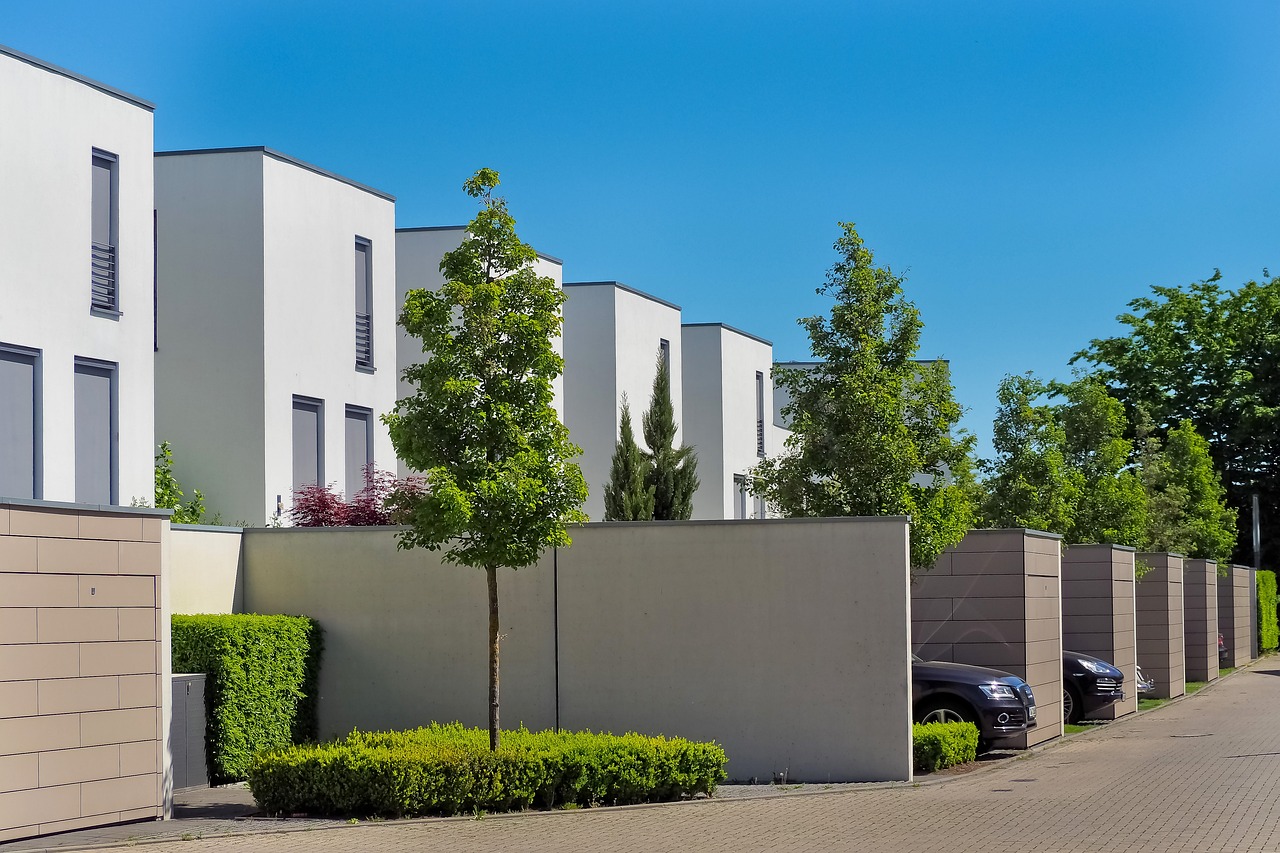 A series of stylish homes nestled among trees and bushes, highlighting a blend of nature and modern residential design.