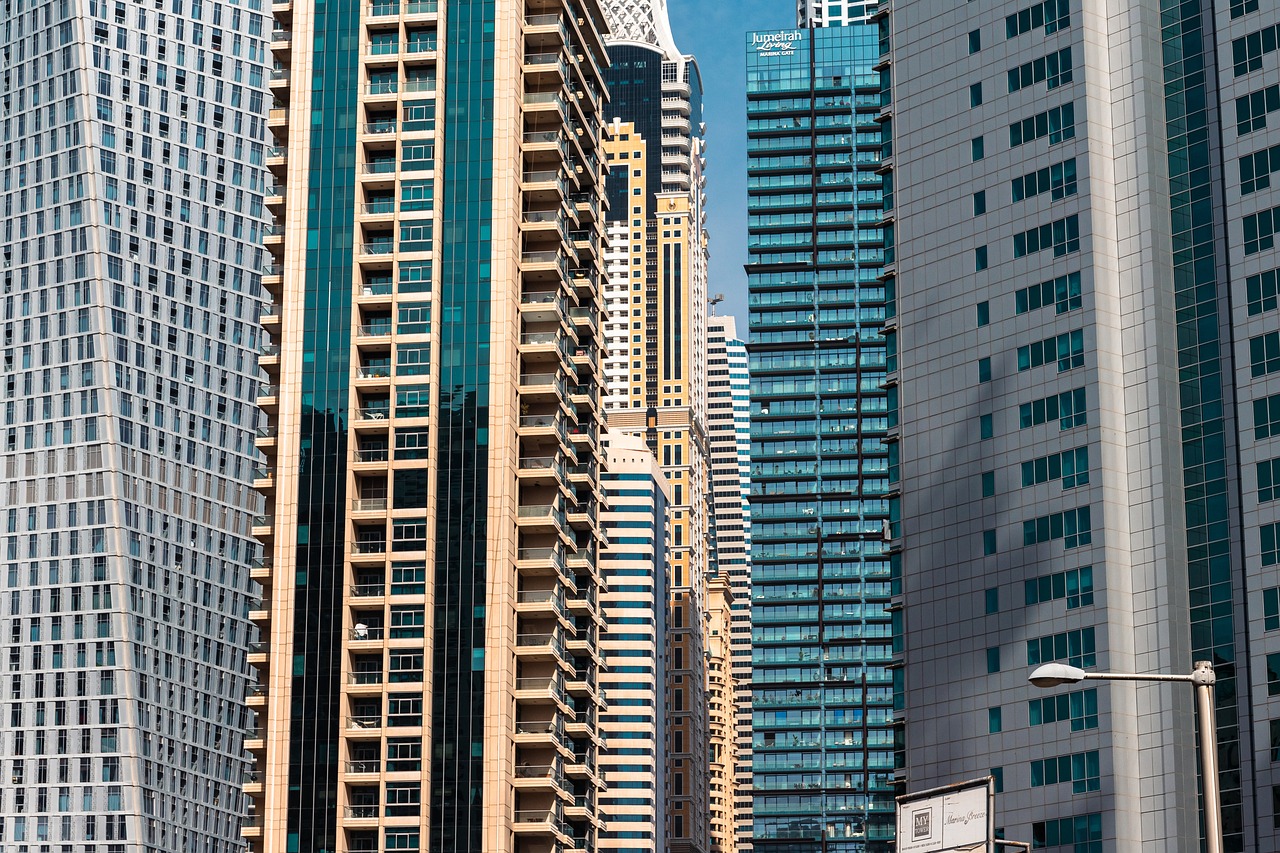 A traffic light positioned on a city street, with tall skyscrapers rising in the background of the downtown landscape.